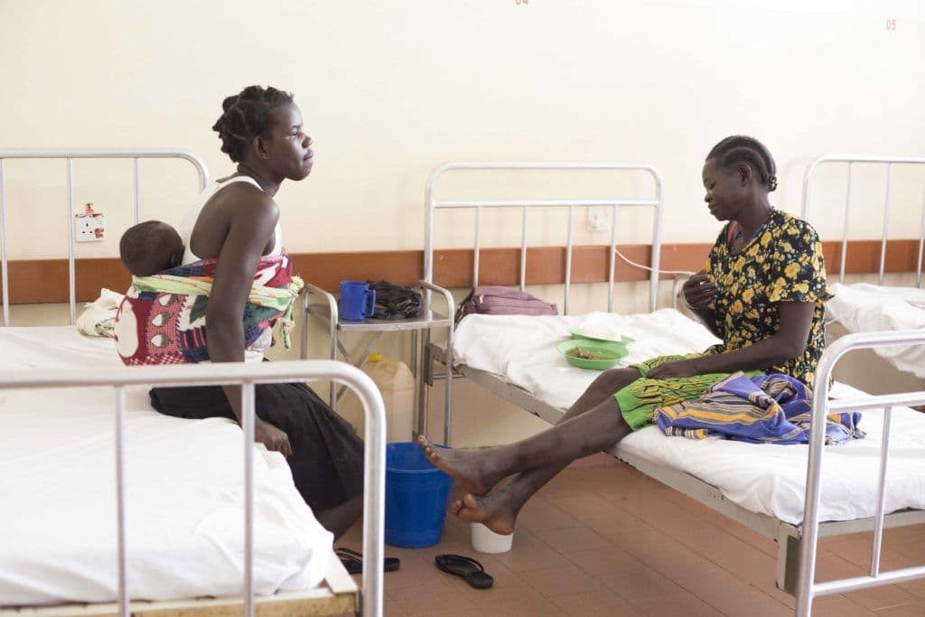 Alice (in floral top) in St.Mary’s Lacor hospital, with her younger sister Robinah, who also happens to be her care taker at the ward.