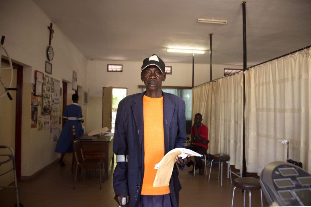 John Ewi poses for a picture shortly before his physiotherapist arrives to get him started on today’s session